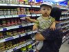 A customer holds a child while shopping at a supermarket in Shenyang