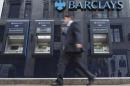A man passes automated teller machines at a Barclays bank branch in London