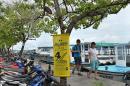 Tourists walk along a dockside next to a election campaign poster in Male on November 12, 2013