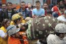 Rescuers carry a miner who sustained injuries after a mine explosion to an ambulance in Soma