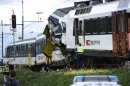 Police inspect the site where two passenger trains collided head-on in Granges-pres-Marnand, western Switzerland, Monday, July 29, 2013. Numerous people have been injured. (AP Photo/Keystone, Laurent Gillieron)