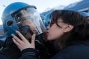 A picture taken on November 16, 2013 shows a demonstrator trying to kiss a riot police officer during a demonstration in Susa against the high-speed train line between Lyon and Turin