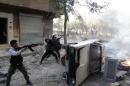 Opposition fighters open fire from behind a car during fighting in the Salaheddin district of Aleppo on October 9, 2013