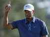 Tiger Woods holds up his ball after putting out on the 18th hole during the third round of the Masters golf tournament Saturday, April 13, 2013, in Augusta, Ga. (AP Photo/David Goldman)