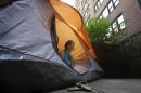 Kathleen Boyle poses for a picture in a tent on the patio of her room at the Affina Hotel in New York, Thursday, Aug. 15, 2013. A couple of New York City locales are offering an unusual option _ the chance to sleep outdoors, incredibly comfortably. It's an urban take on 