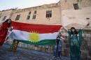 Iraqi Kurdish girls carry a Kurdistan flag in the northern city of Arbil, on December 17, 2013