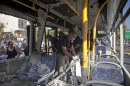 Israeli police officers examine a destroyed bus at the site of a bombing in Tel Aviv, Israel, Wednesday, Nov. 21, 2012. A bomb ripped through an Israeli bus near the nation's military headquarters in Tel Aviv on Wednesday, wounding several people, Israeli officials said. The blast came amid a weeklong Israeli offensive against Palestinian militants in Gaza.(AP Photo/Dan Balilty)