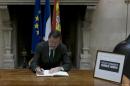 Spanish Prime Minister Mariano Rajoy signs a book of condolences at the French Embassy in Madrid on January 9, 2015 for victims of a terror attack on French satirical weekly Charlie Hebdo that left 12 dead