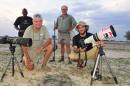 In this photo taken Nov. 9, 2014 photographer Brent Stapelkamp, front right, with colleagues in the Hwange National Park, Zimbabwe. Stapelkamp, a lion researcher and part of a team that had tracked and studied Cecil the lion for nine years darted him and attached a collar last year. He was probably the last person to get up close before Minnesota dentist Walter Palmer killed the now-famous lion with the bushy black mane and, aided by a Zimbabwean professional hunter, cut off its head and skin for trophies. (AP Photo/Derek Whalley)