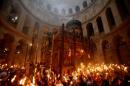 Christian worshippers hold up candles lit from the 'Holy Fire' as thousands gather for the 'Holy Fire' ceremony at the Church of the Holy Sepulchre in Jerusalem's Old City, on April 19, 2014