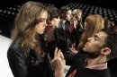 FILE - In this Feb. 15, 2012, file photo, models have their make-up finalized under runway light before the J. Mendel Fall 2012 collection is modeled during Fashion Week, in New York. The 19 editors of Vogue magazines around the world made a pact to project the image of healthy models. They agreed to 