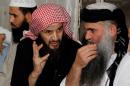 Radical Muslim cleric Abu Qatada listens to Islamist scholar Sheik Abu Mohammad al Maqdisi during a celebration after his release from a prison near Amman