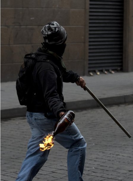 A teacher protesting education reform throws a molotov cocktail at police in Mexico City, on September 13, 2013