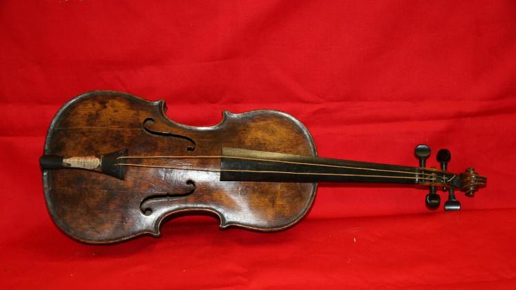 This is an undated handout image from auction house Henry Aldridge and Son made available on Friday Oct. 18, 2013 shows a violin believed to be the one played by Titanic bandmaster Wallace Hartley will now go on auction. It’s a poignant scene familiar to anyone who has watched “Titanic” as the ship slides into the icy waters, musicians perform for the passengers, playing with stoic resolve until the final hour. None of the musicians survived in the 1912 disaster in the North Atlantic. The auction house, which specializes in Titanic memorabilia, expects the violin to fetch more than 200,000 pounds (US$323,300) when it goes on sale Saturday Oct 19, 2013. (AP Photo/Henry Aldridge and Son)