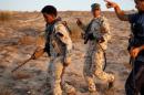 Fighters of Libyan forces allied with the U.N.-backed government walk during reconnaissance patrol in a coastline of Sirte