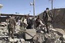 Afghan security forces investigate the site of a bomb blast in Helmand province