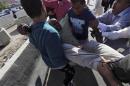 People carry a man who was injured when Libyan militiamen opened fire into a crowd of protesters in Tripoli