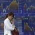 A woman speaks on a mobile phone in front of a securities firm's electronic stock board in Tokyo Monday, June 25, 2012. Asian stocks mostly drifted lower Monday as investors grew cautious ahead of a critical European Union summit later this week where Greek leaders will attempt to renegotiate some terms of the country's international bailout. Japan's Nikkei 225 index was 0.4 percent lower at 8,765.54. (AP Photo/Shizuo Kambayashi)