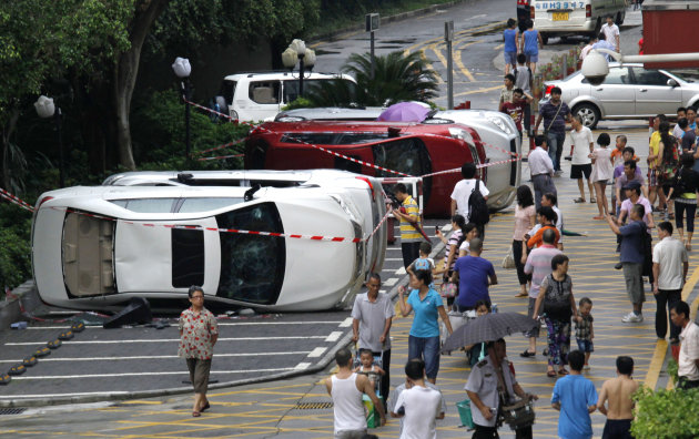 Chinese look at overturned Japanese cars after an anti-Japan protest in Shenzhen, China's Guangdong Province, Sunday, Aug. 19, 2012. Japanese activists swam ashore and raised flags Sunday on an island