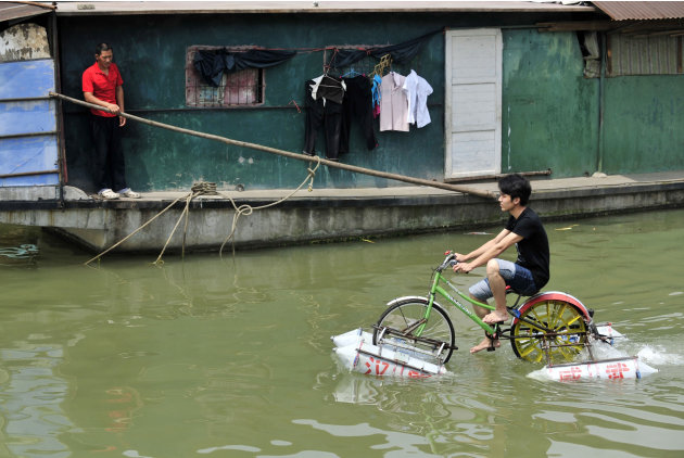 Lei Zhiqian rides a modified bicycle across the Hanjiang River, a tributary of the Yangtze River in Wuhan