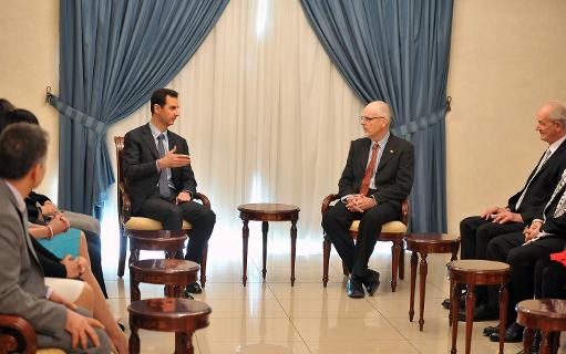 A handout picture released by the official Syrian Arab News Agency (SANA) on December 23, 2013, shows Syrian President Bashar al-Assad (L) speaking to Tim Anderson (C-R), a senior lecturer in political economy at Sydney University, in Damascus