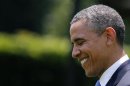 U.S. President Obama smiles while walking towards Marine One at the White House in Washington