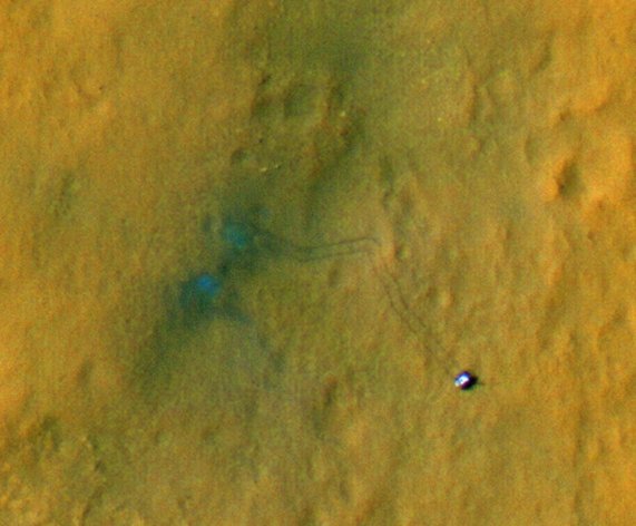TO PROVIDE AND ALTERNATE CROP - This handout image provided by NASA/JPL-Caltech/Univ. of Arizona, shows tracks from the first drives of NASA's Curiosity rover are visible in this image captured by the High-Resolution Imaging Science Experiment (HiRISE) camera on NASA's Mars Reconnaissance Orbiter. The rover is seen where the tracks end. The image's color has been enhanced to show the surface details better. The two marks seen near the site where the rover landed formed when reddish surface dust was blown away by the rover's descent stage, revealing darker basaltic sands underneath. Similarly, the tracks appear darker where the rover's wheels disturbed the top layer of dust. (AP Photo/NASA/JPL-Caltech/Univ. of Arizona) Observing the tracks over time will provide information on how the surface changes as dust is deposited and eroded.