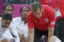 USA head coach Geno Auriemma, top, helps up Croatia guard Sandra Mandir after she was knocked out of bounds during a basketball game at the 2012 Summer Olympics, Saturday, July 28, 2012, in London. (AP Photo/Charles Krupa)