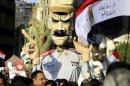Egyptians opposing President Mohamed Mursi hold an effigy mocking him in Tahrir square in Cairo