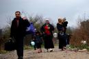 Migrants walk after crossing the border from Greece into Macedonia, near Gevgelija