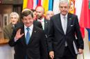 Turkish Prime Minister Ahmet Davutoglu, second left, waves as he leaves an EU summit in Brussels on Monday, March 7, 2016. Turkey on Monday demanded more money from the European Union to help deal with the refugee crisis as EU leaders appealed to Ankara to take back thousands of migrants and prevent others from setting off for Europe. (AP Photo/Geert Vanden Wijngaert)