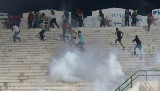 Supporters of Tunisia's Etoile Sportive du Sahel soccer club run as tear gas is fired during clashes in an African Champions League soccer match against Esperance Sportive de Tunis at the Sousse Olympic stadium