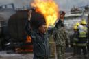 A policeman reacts at the site of burning fuel trucks after a overnight attack by the Taliban on the outskirt of Kabul