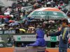 Serbia's Nonak Djokovic sits under an umbrella during a rainfall as he plays Argentina's Guido Pella during their second round match of the French Open tennis tournament at the Roland Garros stadium Thursday, May 30, 2013 in Paris. (AP Photo/Petr David Josek)