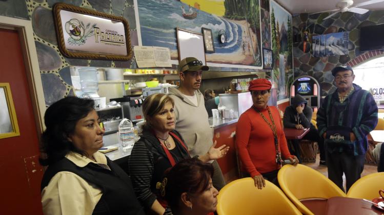King City residents gather at Veronica Villa&#39;s, center with red apron, restaurant to discuss a police car theft ring on Wednesday, Feb. 26, 2014, in King City, Calif. The district attorney charged four police officers and a civilian in a scheme to steal cars from poor Latinos by having their cars impounded at a local tow yard. When the motorists were unable to pay their fees, the tow yard operator sold the cars or gave them for free to police officers. (AP Photo/Marcio Jose Sanchez)