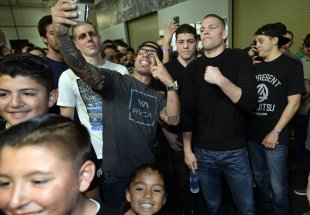 Nate Diaz (R) poses with fans before a news conference with Conor McGregor. (Getty Images)