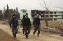 Free Syrian Army fighters walk with weapons at Tameko pharmaceutical factory, after FSA claimed to have taken control of factory, in eastern al-Ghouta, near Damascus