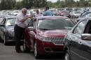 Auto dealership owners take a look at vehicles during an auto auction in Carleton