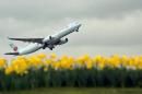 An Air Canada plane is pictured over a bed of daffodils as it takes off from London Heathrow Airport on March 25, 2010