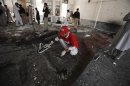 A rescue worker collects evidence from the site of a suicide bomb attack at a Shi'ite Muslim mosque in Peshawar