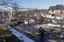 Police officers walk near the debris of the previous day's explosion at a townhouse complex in Ewing, N.J. on Wednesday, March, 5, 2014. Investigators are looking to determine what triggered a natural gas leak and explosion that devastated the development, killing one woman and injuring seven workers. (AP Photo/Mel Evans)