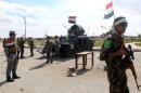 Iraqi police and Sunni fighters stand on March 22, 2015 at a checkpoint at the entrance of Al-Alam, a flashpoint town north of Tikrit