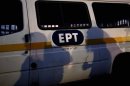 Protesters cast their shadows on a state broadcaster ERT van outside its headquarters in Athens