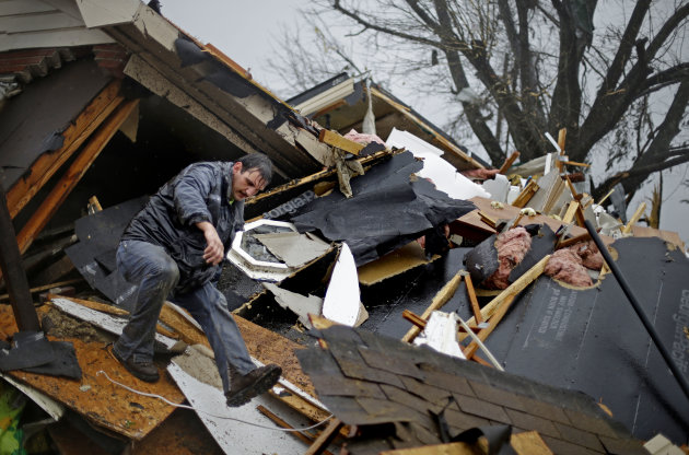 Nathan Varnes, of Cartersville, Ga., helps search a destroyed home for a dog after a tornado struck, Wednesday, Jan. 30, 2013, in Adairsville, Ga. A fierce storm system that roared across Georgia has left at least one person dead after it demolished buildings and flipped vehicles on Interstate 75 northwest of Atlanta. (AP Photo/David Goldman)