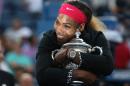 Serena Williams, of the United States, hugs the championship trophy after defeating Caroline Wozniacki, of Denmark, during the championship match of the 2014 U.S. Open tennis tournament, Sunday, Sept. 7, 2014, in New York. (AP Photo/Mike Groll)