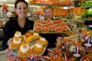 Sandra Terpstra, left, and Linda Clewits pose with trays of cakes made for Queen's Day, a national holiday and the day of the abdication of Queen Beatrix and the crowning of the new King, at a Arnold Cornelis pastry shop in Amsterdam, Netherlands, Thursday April 23, 2013. The shop was decorated with Dutch flags and the color of the Dutch royals, the House of Orange. Queen Beatrix has announced she will relinquish the crown on April 30, 2013, after 33 years of reign, leaving the monarchy to her son Crown Prince Willem Alexander. (AP Photo/Peter Dejong)