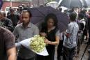 People bring flowers to pay respect to the people who died at Holey Artisan Bakery in Dhaka's Gulshan area, Bangladesh, Sunday, July 3, 2016. The assault on the restaurant in Dhaka's diplomatic zone by militants who took dozens of people hostage marks an escalation in militant violence in the Muslim-majority nation. (AP Photo)