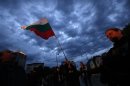 A protester waves the Bulgarian flag during a protest outside the National Palace of Culture, where the political parties in the elections will be holding news conferences, in Sofia