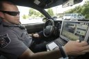 Officer Dennis Vafier, of the Alexandria Police Department, uses a laptop in his squad car to scan vehicle license plates during his patrols, Tuesday, July 16, 2013, in Alexandria, Va. Local police departments across the country have amassed millions of digital records on the location and movements of vehicles with a license plate using automated scanners. Affixed to police cars, bridges or buildings, the scanners capture images of passing or parked vehicles and note their location, dumping that information into police databases. Departments keep the records for weeks or even years. (AP Photo/Pablo Martinez Monsivais)