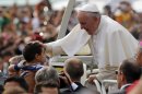 Pope Francis blesses a child as he rides on the popemobile to celebrate mass in Rio de Janeiro Sunday July 28, 2013. Hundreds of thousands of young people slept under chilly skies in the white sand of Copacabana awaiting Pope Francis' final Mass for World Youth Day.(AP Photo/Jorge Saenz)